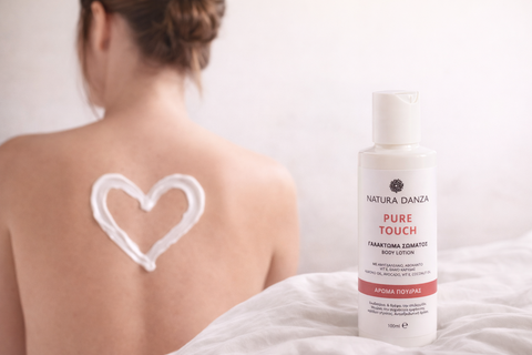 Γυναίκα με γυρισμένη πλάτη και καρδιά από γαλάκτωμα σώματος Pure Touch της NATURA DANZA, με το προϊόν σε πρώτο πλάνο